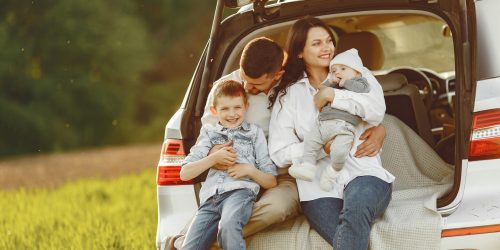 Family in a forest. People by the car. Sunset background.